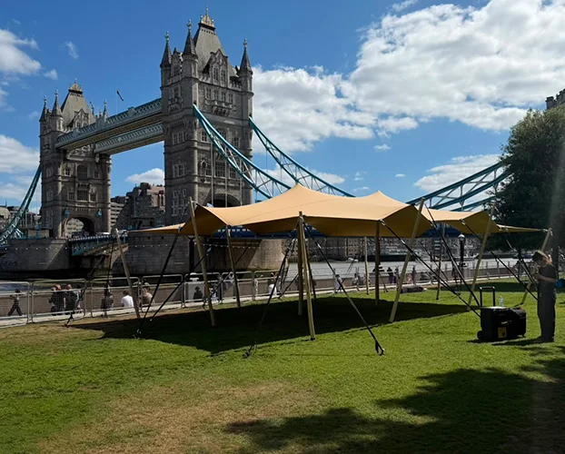 Festival bar and seating arranged beneath a stretch tent