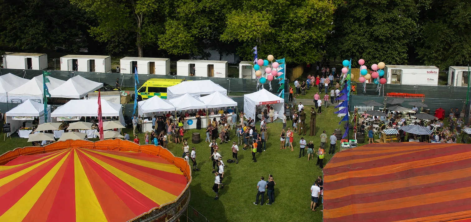 Multiple temporary marquee structures arranged across a festival site